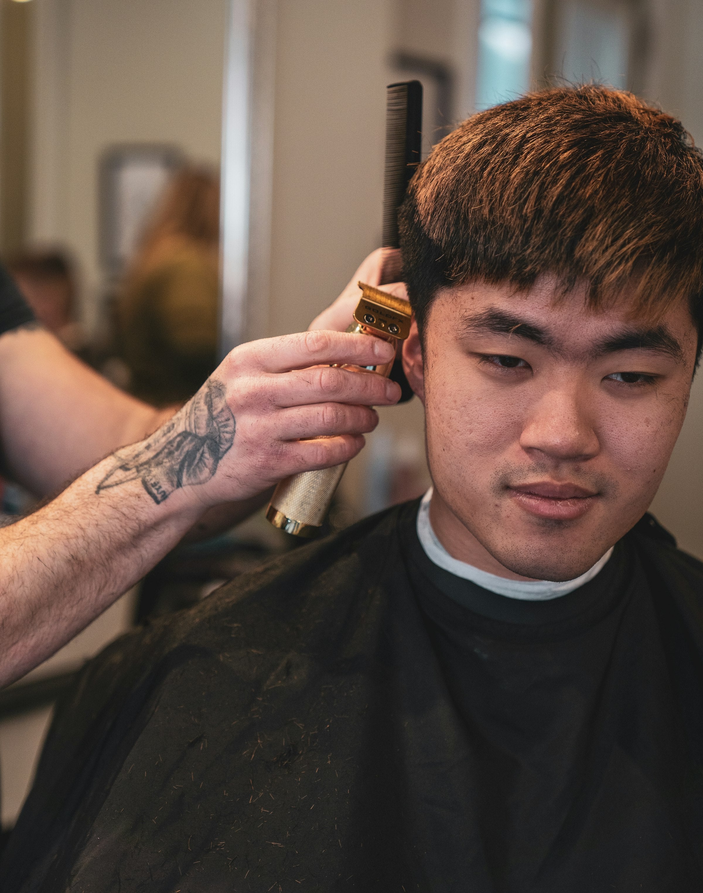 Barbero profesional cortando el pelo a un cliente