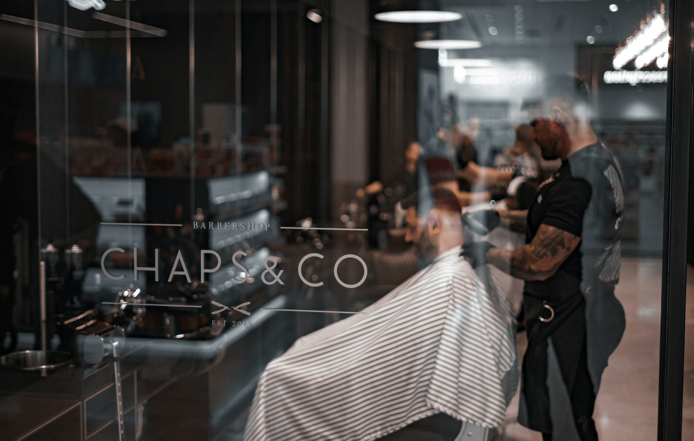 Interior de barbería profesional con clientes